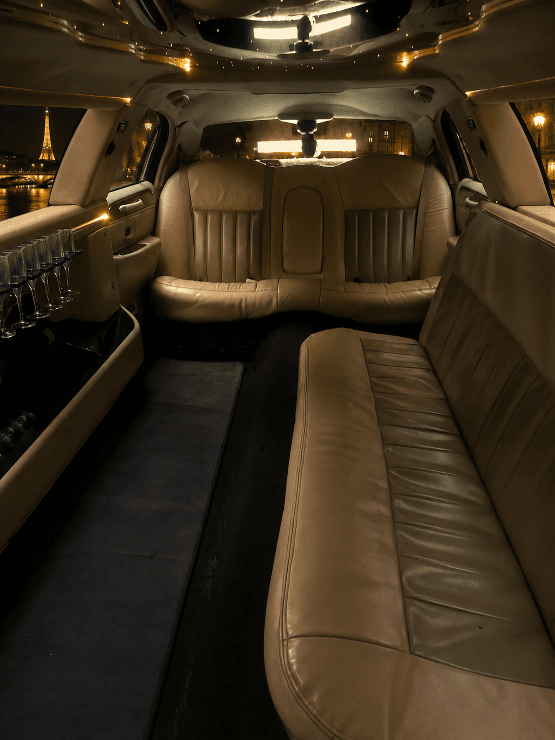 Intérieur de limousine avec banquettes cuir et vue sur la Tour Eiffel